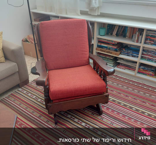 כורסה עם ריפוד אדום על שטיח צבעוני